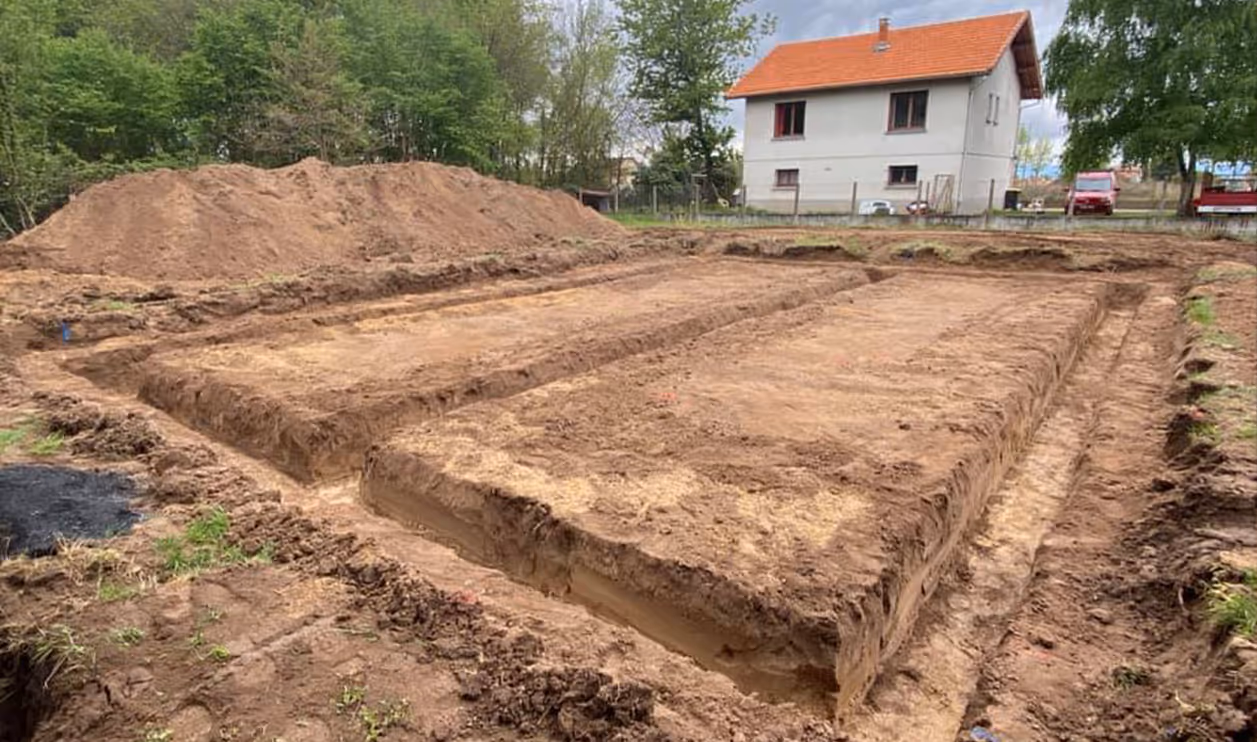 Fondations en cours de terrassement devant une maison sur un chantier d’Habitat Construction à Aulnat